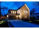 Beautiful two-story home with brick and siding accents, a modern garage door, and professional landscaping at twilight at 3087 S Dexter Way, Denver, CO 80222