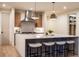 Modern kitchen with island, sleek countertops, pendant lights, and barstool seating at 3087 S Dexter Way, Denver, CO 80222
