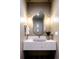 Elegant powder room features a unique vessel sink, marble countertop, and modern lighting at 3087 S Dexter Way, Denver, CO 80222