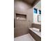 Stylish shower featuring textured tile walls, a built-in shelf, and a comfortable bench at 3087 S Dexter Way, Denver, CO 80222