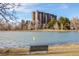 Apartment building viewed from a park featuring lake and bench at 460 S Marion Pkwy # 1106, Denver, CO 80209