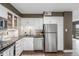 Kitchen with white cabinets, stainless-steel appliances, and hardwood floors at 460 S Marion Pkwy # 1106, Denver, CO 80209