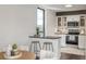 Kitchen with white cabinets, a stone backsplash, bar seating, and a window with views at 460 S Marion Pkwy # 1106, Denver, CO 80209