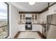 Bright kitchen with a stone backsplash, white cabinets, and stainless-steel appliances at 460 S Marion Pkwy # 1106, Denver, CO 80209