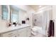Modern bathroom with white cabinets, granite countertop, and bathtub-shower with grey surround at 5932 Eldora St, Golden, CO 80403