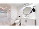 Updated bathroom with white vanity, modern fixtures, and a stylish round mirror at 5932 Eldora St, Golden, CO 80403