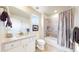 White bathroom features a granite countertop, bathtub, and shower with stone surround at 5932 Eldora St, Golden, CO 80403