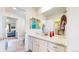 Bright bathroom featuring granite countertops, a large mirror, and access to the bedroom and walk-in closet at 5932 Eldora St, Golden, CO 80403