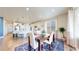 Cozy dining area with a wooden table and chairs, next to a kitchen with white cabinetry and lots of natural light at 5932 Eldora St, Golden, CO 80403
