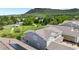 Grey two-story house with roof and windows overlooking a neighborhood with lots of greenery and a distant mountain at 5932 Eldora St, Golden, CO 80403