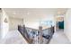 Upstairs hallway with iron railing overlooking the living room, and bright natural light at 5932 Eldora St, Golden, CO 80403