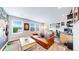 Bright living room features multiple windows, leather couch, and home office at 5932 Eldora St, Golden, CO 80403