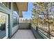 Balcony featuring green railings, a grey floor, and a view of the surrounding forest at 31819 Rocky Village Dr # 301, Evergreen, CO 80439