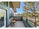 Relaxing balcony area featuring two chairs, a table, and views of lush greenery at 31819 Rocky Village Dr # 301, Evergreen, CO 80439