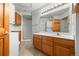 Full bathroom with stacked laundry units, wood cabinets, and a tiled floor at 31819 Rocky Village Dr # 301, Evergreen, CO 80439