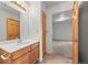 Bright bathroom with tile floor, wood vanity, and an open view to bedroom at 31819 Rocky Village Dr # 301, Evergreen, CO 80439