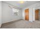A bright bedroom featuring neutral carpet, white walls, and natural light from a window and doorway at 31819 Rocky Village Dr # 301, Evergreen, CO 80439