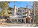 Charming building exterior featuring stone accents and multiple balconies, nestled among trees at 31819 Rocky Village Dr # 301, Evergreen, CO 80439