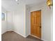 Hallway with light brown carpet and a wooden door with a brass knocker at 31819 Rocky Village Dr # 301, Evergreen, CO 80439