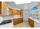Bright kitchen with wooden cabinets, tiled backsplash, and mountain view from window at 31819 Rocky Village Dr # 301, Evergreen, CO 80439