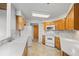 Well-lit kitchen featuring white appliances, tile floors, and wooden cabinetry at 31819 Rocky Village Dr # 301, Evergreen, CO 80439