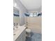 Traditional bathroom featuring blue tile floor, white tile walls, a bathtub with shower, and a vanity with a sink at 1085 Victor St, Aurora, CO 80011