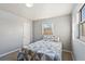 Neutral bedroom with a double bed, light gray walls, a white door and carpeted floors, illuminated by natural light at 1085 Victor St, Aurora, CO 80011
