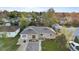 Aerial view of a charming stone-clad home with mature trees and a basketball hoop in the driveway at 1085 Victor St, Aurora, CO 80011