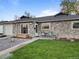 Attractive stone facade with a well-kept lawn and a basketball hoop in the driveway at 1085 Victor St, Aurora, CO 80011