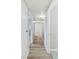 Long, bright hallway with wood laminate floors, white trim, and neutral walls, leading to inviting living spaces at 1085 Victor St, Aurora, CO 80011