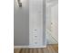 Hallway featuring wood laminate flooring, a built-in storage cabinet, and neutral wall paint, creating a transitional space at 1085 Victor St, Aurora, CO 80011