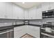 Kitchen with white cabinets, black countertops and stainless steel appliances at 1085 Victor St, Aurora, CO 80011