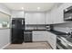 Kitchen boasts white cabinets, black countertops and stainless steel appliances at 1085 Victor St, Aurora, CO 80011