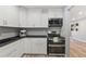 Bright kitchen features white cabinets, black countertops and stainless steel appliances at 1085 Victor St, Aurora, CO 80011