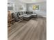 Cozy living area featuring hardwood floors, a gray sectional couch, and plenty of natural light at 1085 Victor St, Aurora, CO 80011