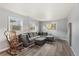 Cozy living room features a gray sectional sofa, ottoman, and wood-look flooring at 1085 Victor St, Aurora, CO 80011