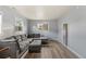 Living room features a gray sectional sofa, ottoman, and wood-look flooring at 1085 Victor St, Aurora, CO 80011