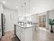 A well-lit kitchen offers an island with a sink, stainless steel appliances, and flows into the dining and living area at 13754 Ash Cir, Thornton, CO 80602
