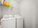 Functional laundry room with modern washer and dryer, plus wire shelving at 13754 Ash Cir, Thornton, CO 80602