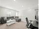 Bright loft area features a gray sectional couch, white coffee table, and a functional workstation with a desk and chair at 13754 Ash Cir, Thornton, CO 80602