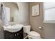 Charming half bath featuring a patterned accent wall, round mirror, and modern fixtures at 15122 Fillmore Way, Thornton, CO 80602