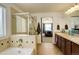 Elegant bathroom showcasing a soaking tub, glass-enclosed shower, and a double vanity with updated fixtures at 15122 Fillmore Way, Thornton, CO 80602