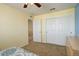 This is a light and airy bedroom with light yellow walls, closet with a white sliding door, and tan carpet at 15122 Fillmore Way, Thornton, CO 80602