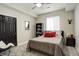 A charming bedroom featuring a gray wall, a dark book shelf, a black accent door, and neutral carpet at 15122 Fillmore Way, Thornton, CO 80602