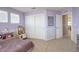 This is a bedroom featuring purple walls, white trim, white closet doors, neutral-colored carpet, and natural light at 15122 Fillmore Way, Thornton, CO 80602
