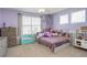 Bright bedroom featuring natural light from two windows, gray walls, a turquoise bench, and toys at 15122 Fillmore Way, Thornton, CO 80602