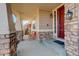 Welcoming front porch with a decorative bench and stylish exterior lighting by a red door at 15122 Fillmore Way, Thornton, CO 80602