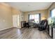 Versatile living area showcases a dedicated workspace, massage chair, and natural light from the large window at 15122 Fillmore Way, Thornton, CO 80602