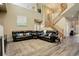 Inviting living room with hardwood floors, large sectional, and staircase leading to the upper level at 15122 Fillmore Way, Thornton, CO 80602