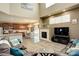 Open-concept living room with a kitchen, dining area, fireplace, and large windows for natural light at 15122 Fillmore Way, Thornton, CO 80602